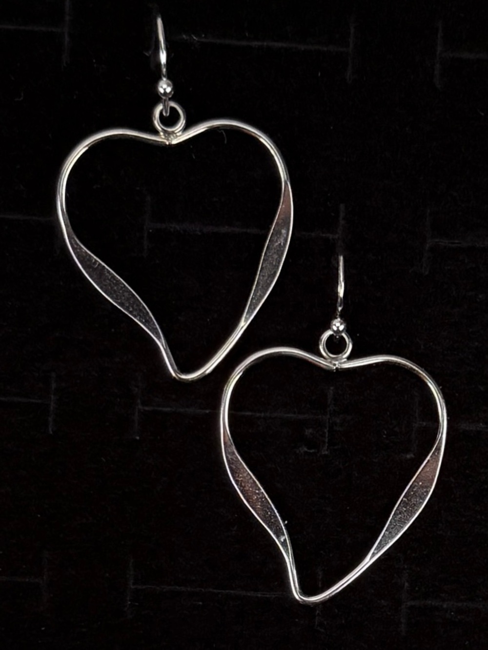Sweet and contemporary pierced dangle earrings featuring open heart silhouette